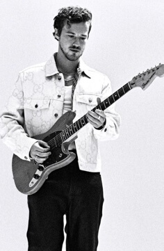 Joseph Quinn with his guitar.